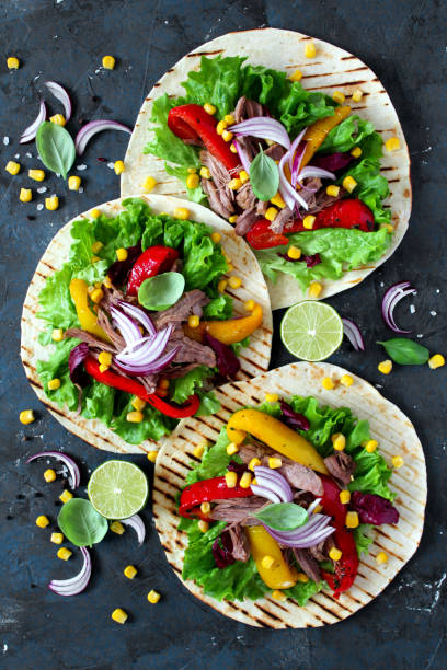 istock Tortillas flat various vegetables and beef for tacos or burrito on stone background. 1138009997