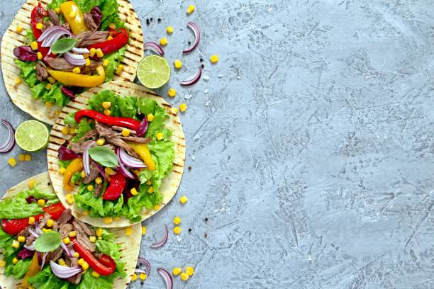 istock Tortillas flat various vegetables and beef for tacos or burrito on stone background. 1138011461