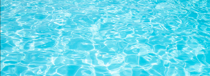 Turquoise pool water surface with ripples and waves on sunny day