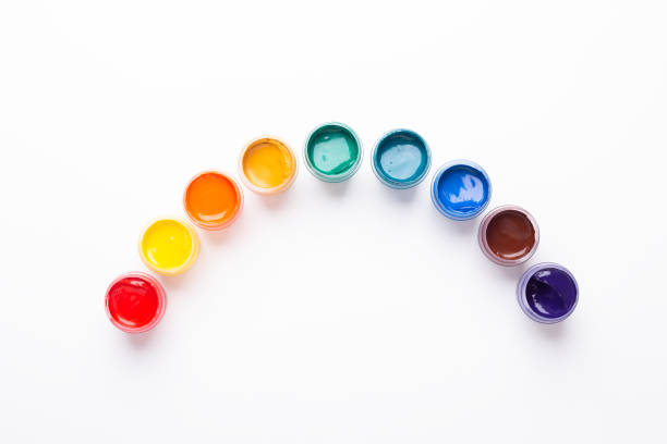 Multicolored gouache on a white background Rainbow shape Isolated Paints in containers Top view Copy space