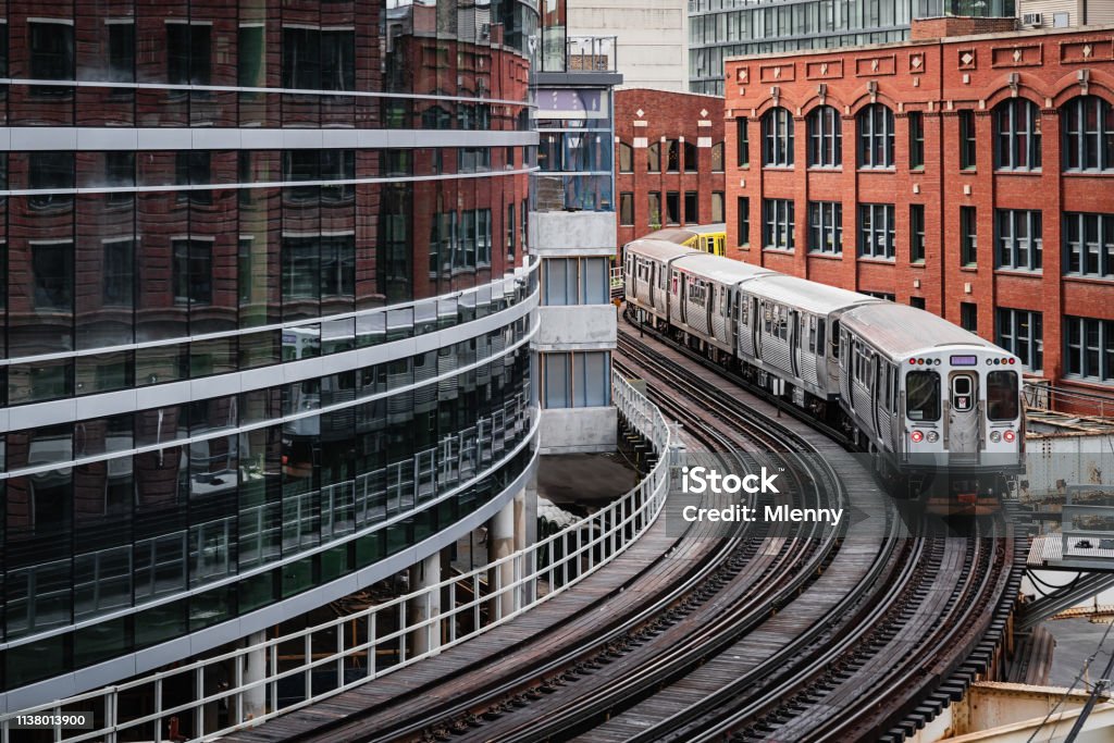 Chicago CTA Elevated Train Downtown Urban Buildings Chicago typical silver colored commuter train moving on elevated tracks to railroad station in between urban city buildings of Chicago, Illinois, USA. Chicago - Illinois Stock Photo