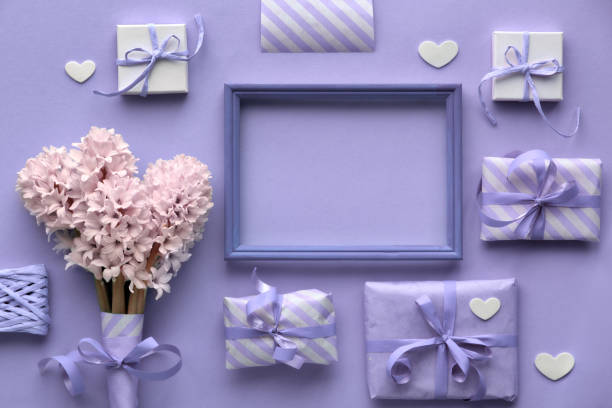 istock Purple springtime  background with pink hyacinth flowers, wrapped gift boxes and decorative hearts around wooden frame 1138014428