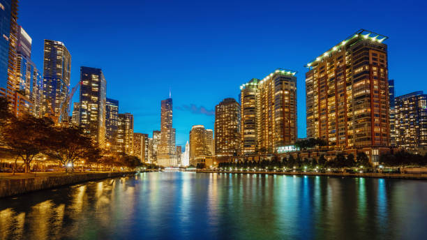 Panorama of illuminated Chicago Cityscape from Chicago River Waterfront at Dusk. Long time exposure. Chicago, Illinois, USA.