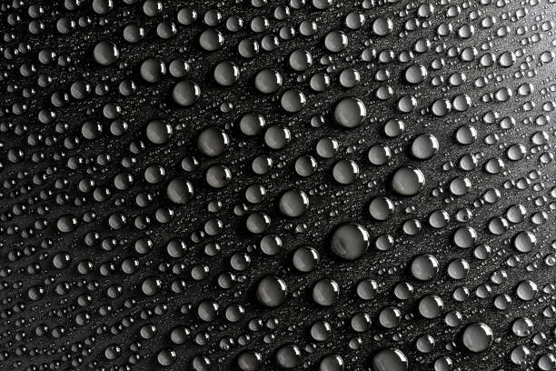 istock Droplets of water on a black, matte background illuminated with a delicate light. 1138017028