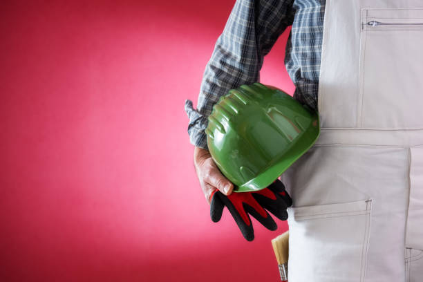 istock House painter worker with helmet and gloves in hand. Building. 1138018089