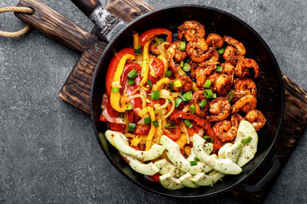 shrimp fajitas with bell pepper and onion cooked in a frying pan, top view shrimp fajitas with bell pepper and onion cooked in a frying pan, top view fajita photos stock pictures, royalty-free photos & images