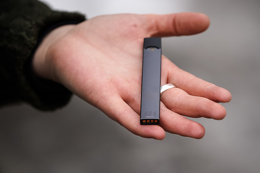 A woman is holding a Juul e-cigarette, in Montreal.