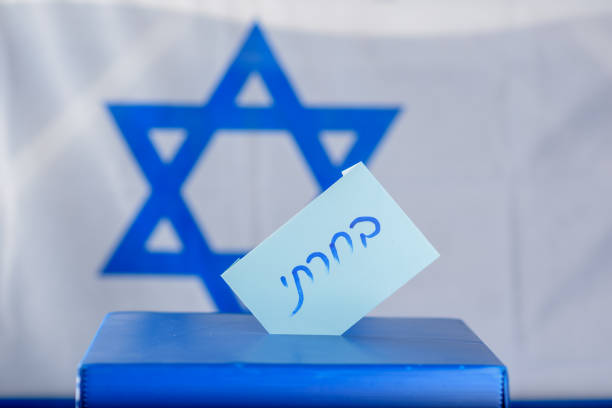 istock Vote box on election day. Hebrew text I voted on voting paper . 1138021447