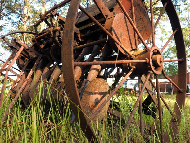 Disused farm implements and machinery lay rusting in a paddock in Australia. Antique farm equipment that is no longer being used.