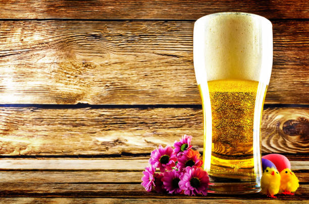 Glass of cold light beer with Easter decorations on a wood background for the Easter holidays. toning. selective focus