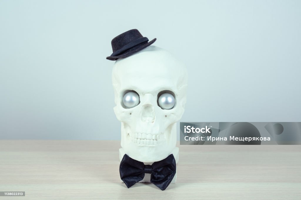 skull sculpture with black hat and a black  bow tie.  holiday background concept. Free space for design. Abstract Stock Photo