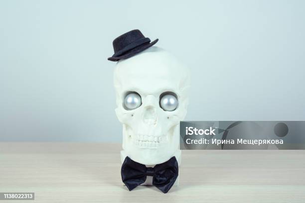 Skull Sculpture With Black Hat And A Black Bow Tie Holiday Background Concept Free Space For Design Stock Photo - Download Image Now