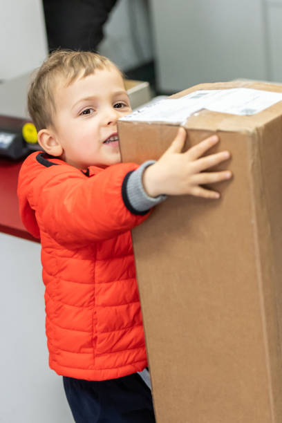 istock Three years old little child holding a parcel package at the post office 1138026248
