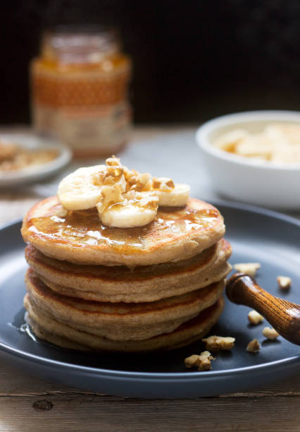 istock Pancakes with banana, nuts and honey, served with tea. Rustic style. 1138026843