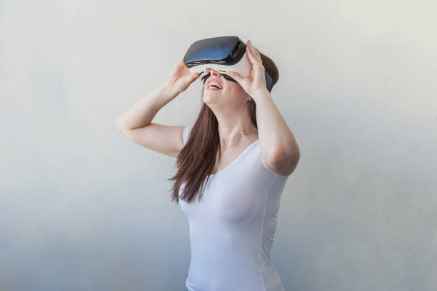 istock Smile young woman wearing using virtual reality VR glasses helmet headset on white background 1138031138