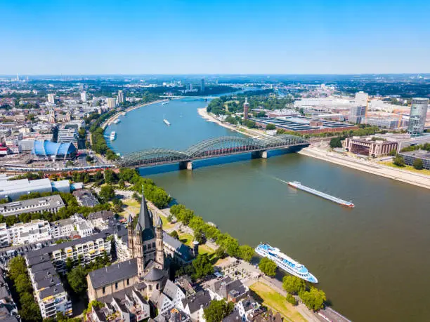 Great Saint Martin Church and Hohenzollern Bridge through Rhine river in Cologne, Germany