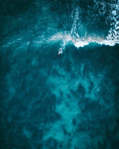 istock Aerial shot of a surfer riding a wave 1138040892