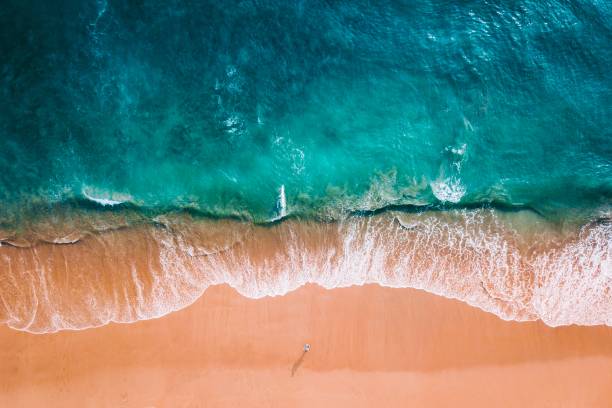 Aerial shot of a beach blue ocean and orange sand waters edge stock pictures, royalty-free photos & images
