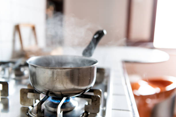 빈티지 타일 가스 난로 상단 타일 흰색 싱크대와 스테인레스 스틸 냄비와 스팀 주방에서 푸른 불꽃으로 요리를 하 고 있습니다. - steam saucepan fire cooking 뉴스 사진 이미지