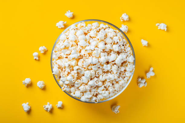 istock Glass bowl with salted popcorn on yellow background. Top view with copy space. Flat lay 1138045832