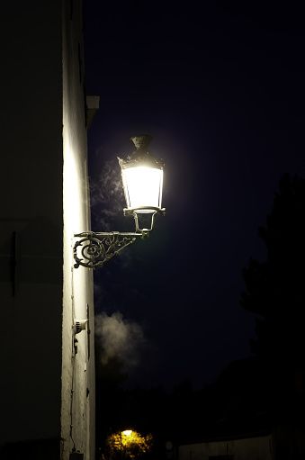 Street lamp lit at night in urban street, technology