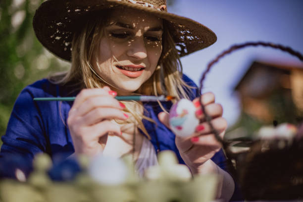 istock Young woman coloring Easter eggs on a sunny day 1138047601