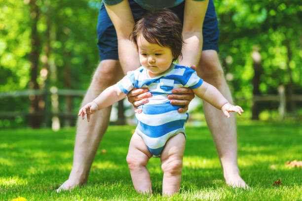 istock Baby boy learning to walk outside 1138048786
