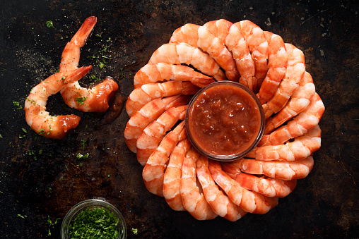 Ring of tiger shrimps with cocktail sauce and seasoning