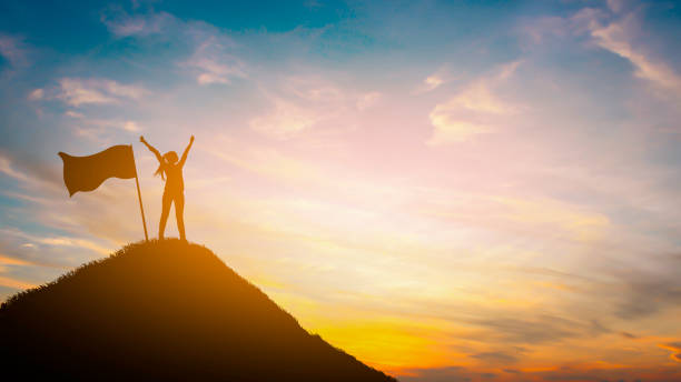 Silhouette woman on top hill in sunet stock photo