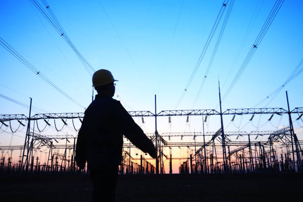 istock Electricity workers and pylon silhouette 1138051078
