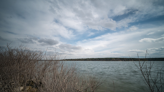 Wide Angle View of Large Lake from the the Shoreline behind dry branches