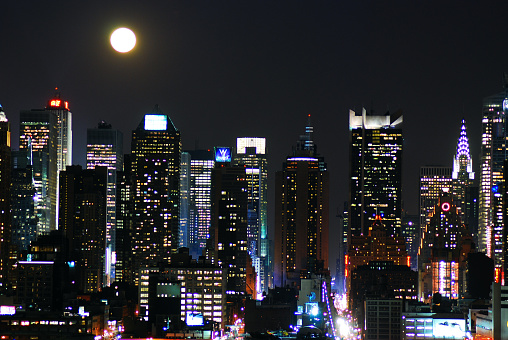 New York, NY, USA April 9, 2009 A Full Moon Rises Over the skyline of Midtown Manhattan, New York City