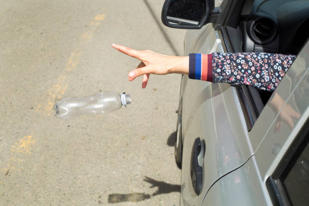 istock Hand throwing plastic bottle on the road 1138056660