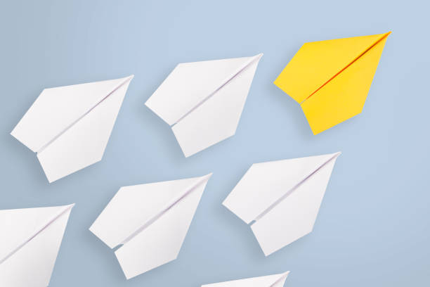 istock Leadership concepts with yellow paper airplane leading among white 1138057847