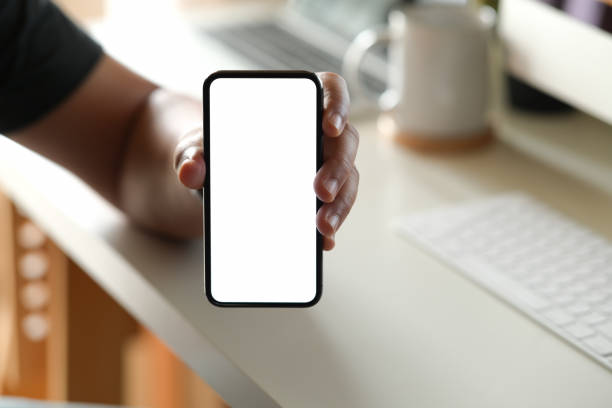 istock Man showing blank screen mobile phone at office 1138064468