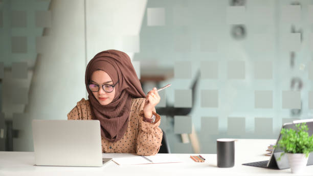 istock Attractive muslin woman working in office 1138064614
