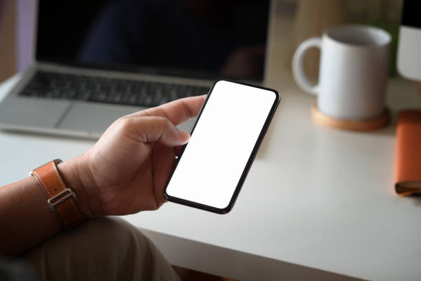 istock Blank screen mock up mobile phone in man hand at office 1138064693