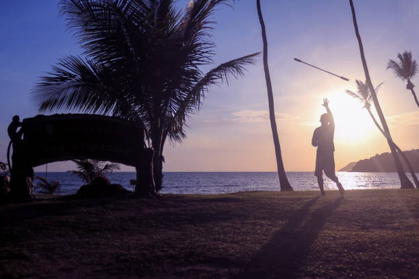 istock Man spinning contact staff or stick on the beach with sunrise 1138070607