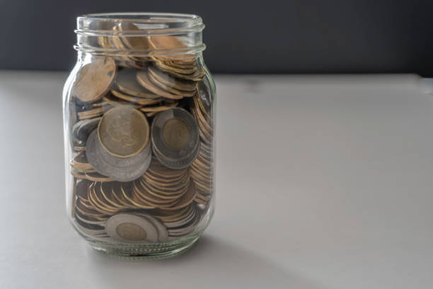 istock A jar full of coins on white and black background 1138070831