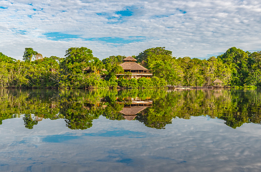 The reflection of an amazon rainforest lodge inside Yasuni national park, Ecuador. The tributaries of the Amazon river comprise the countries of Suriname, Guyana, French Guyana, Venezuela, Colombia, Ecuador, Peru, Bolivia and Brazil.
