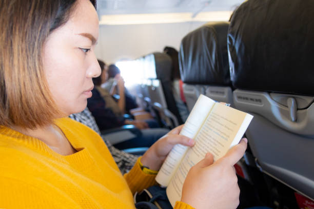 istock asian woman reading book on plane 1138071873