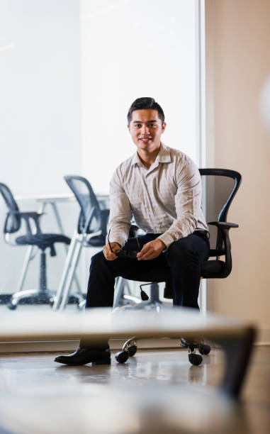 istock Young Vietnamese businessman in office chair 1138074221