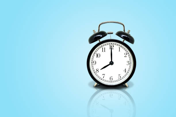 istock Retro black alarm clock showing eight o'clock isolated on blue background. 1138077187