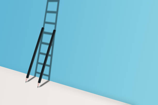 istock Business Creative and Idea Concept : Two black pencils standing on white floor and shadow in ladder shape shading on blue wall. 1138077318