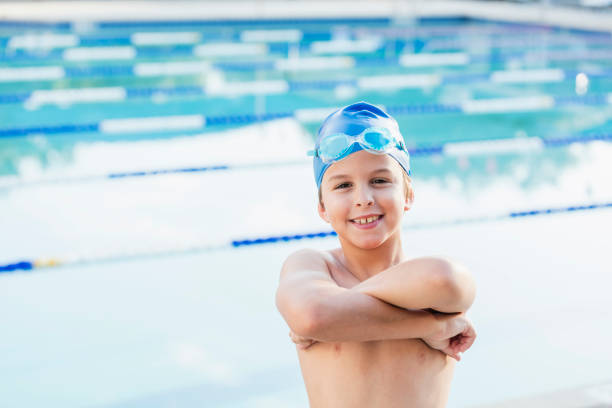 istock Boy at swimming pool wearing swim cap 1138079462