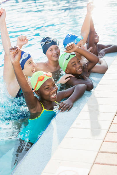 istock Multi-ethnic children on swim team in pool, cheering 1138079560