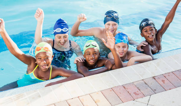 istock Multi-ethnic children on swim team in pool, cheering 1138079611