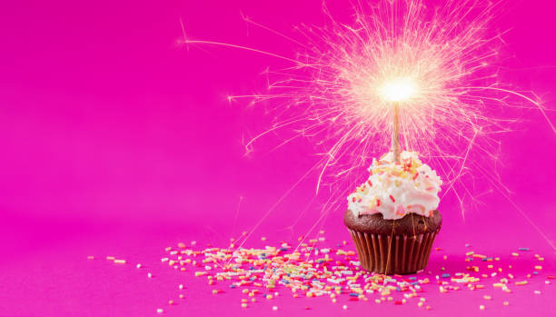 istock Birthday Cupcake with a sparkler at pink background 1138081520