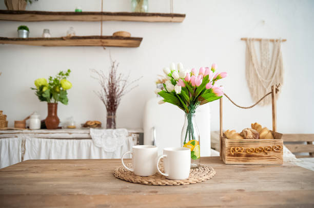 istock Summer kitchen interior in rustic style. Bright kitchen with a wooden table. Spring flowers and bread in a basket on the table in the kitchen 1138086102