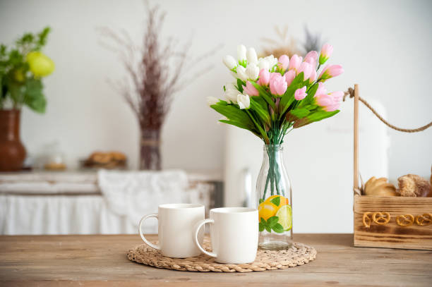 istock Summer kitchen interior in rustic style. Bright kitchen with a wooden table. Spring flowers and bread in a basket on the table in the kitchen 1138086110